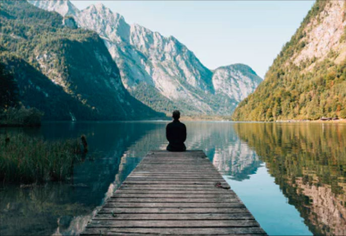 person sitting by lake